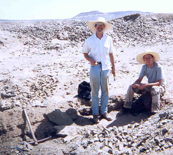 two figures standing in desert landscape 