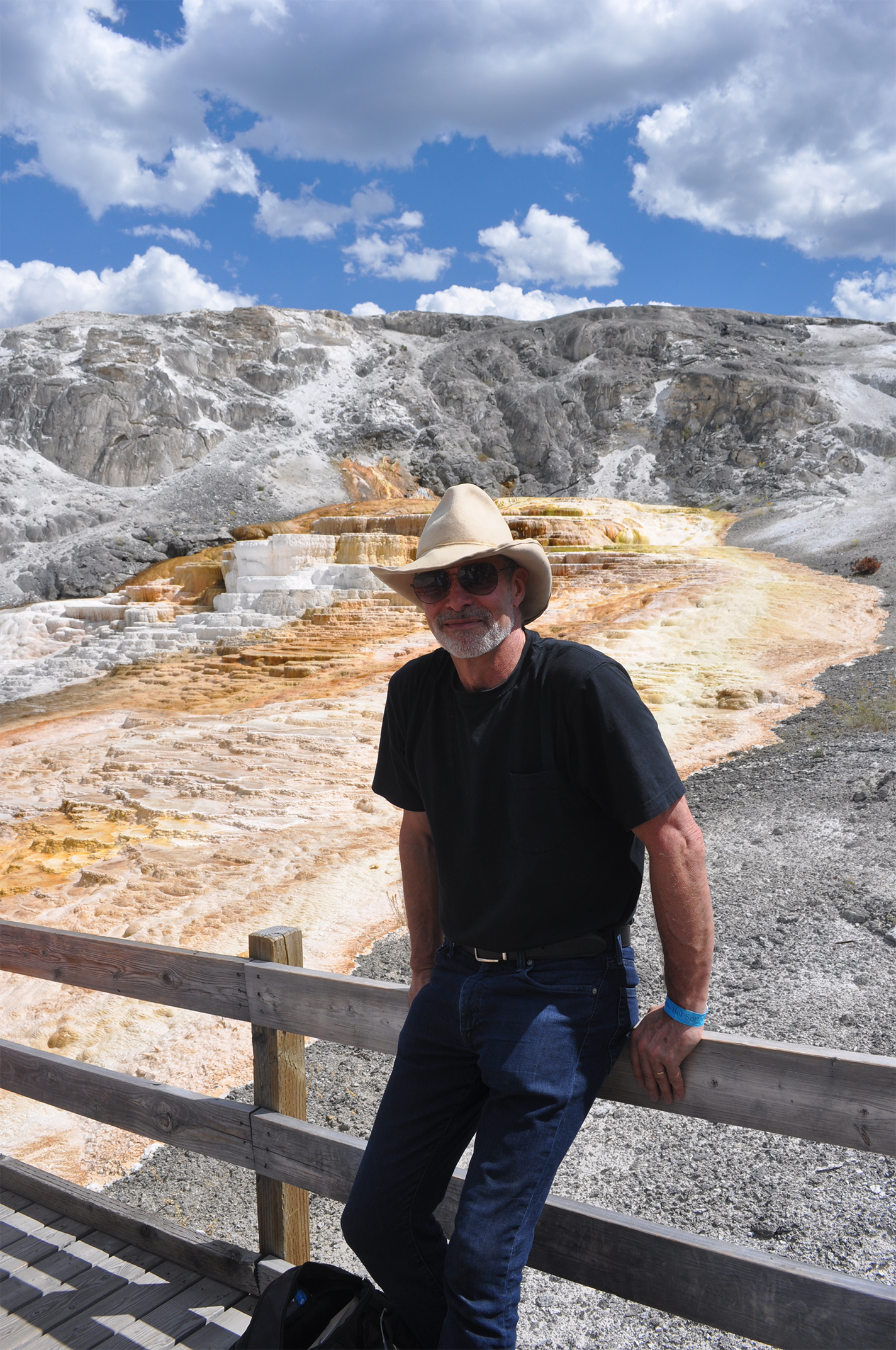 Robert Hazen in front of a travertine hot spring (depositing terraced limestone) in Yellowstone National Park.